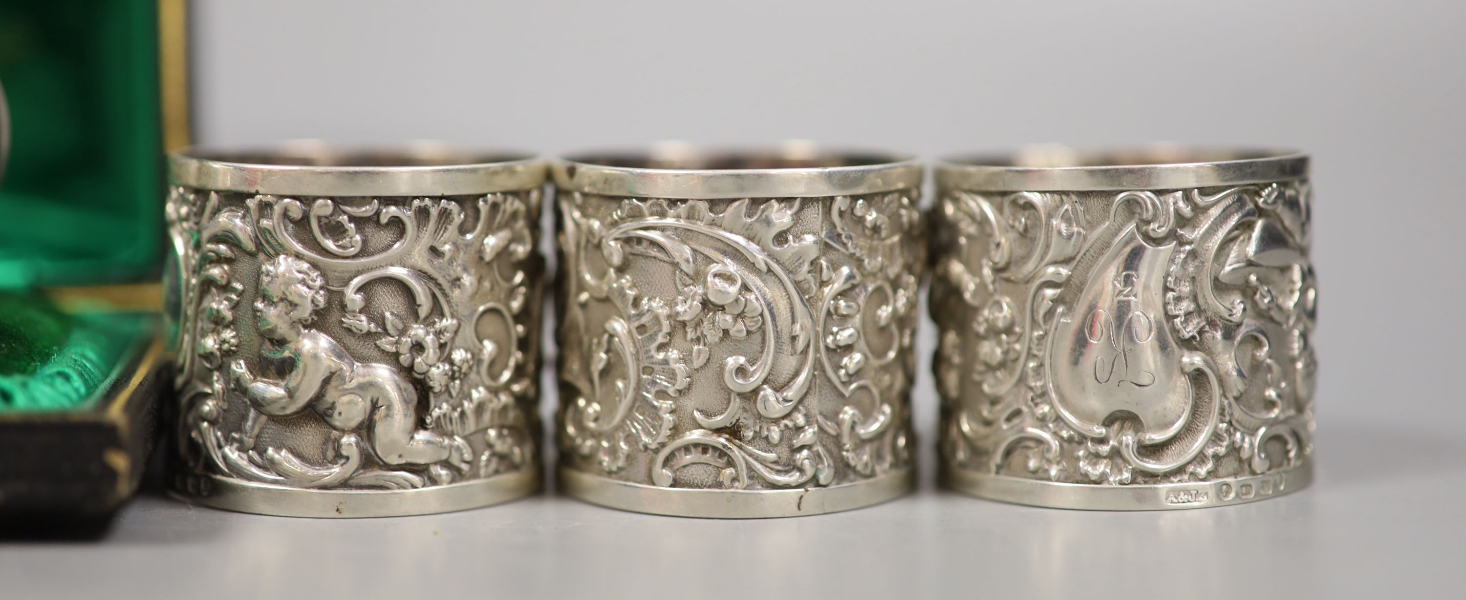 A set of four Victorian embossed silver napkin rings, A & J. Zimmerman, Birmingham, 1889 and four other silver napkin rings including one cased, 7.5oz.